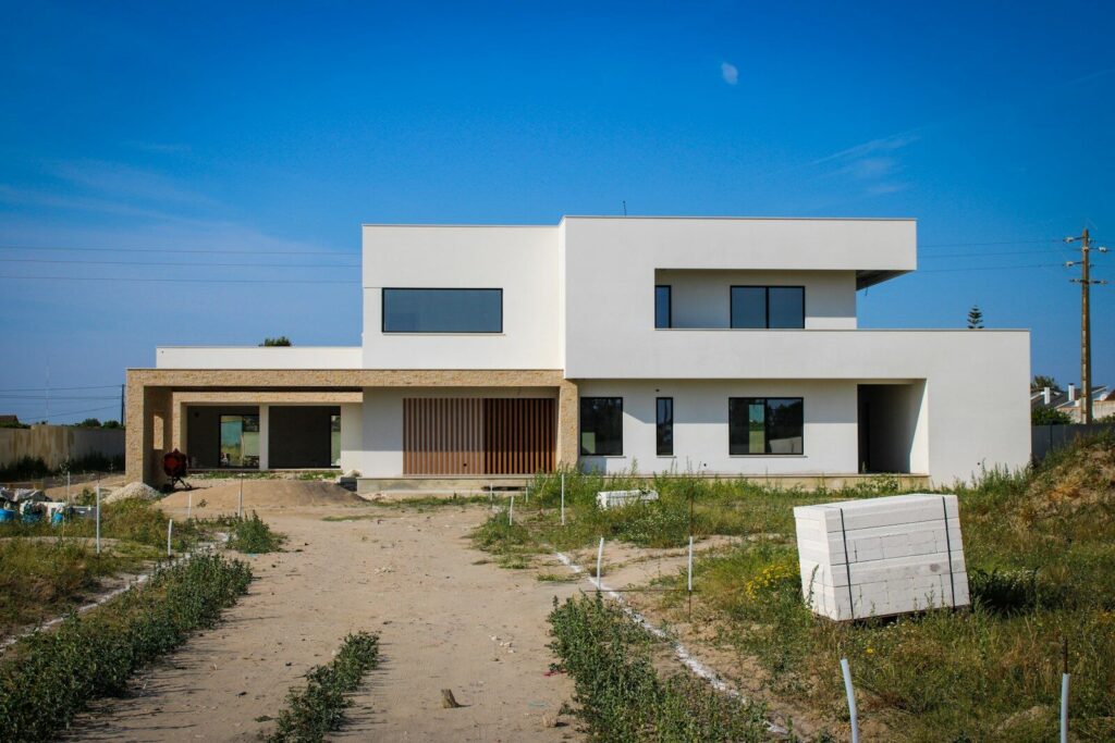 a large white house sitting on top of a dirt road