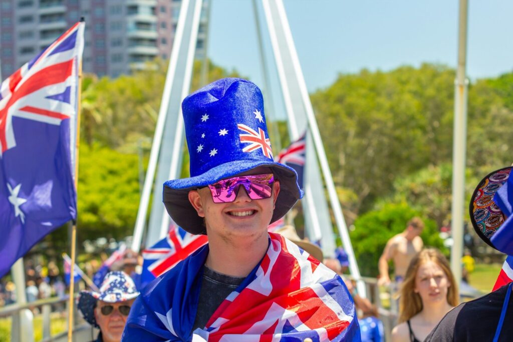 Man in australian flag hat and scarf smiles
